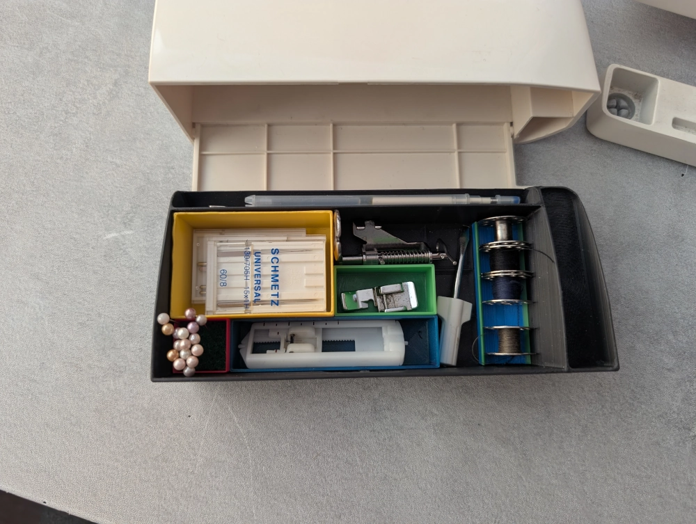 Stalčiukas su dėžutėmis ir daiktais. Vaizdas iš viršaus.