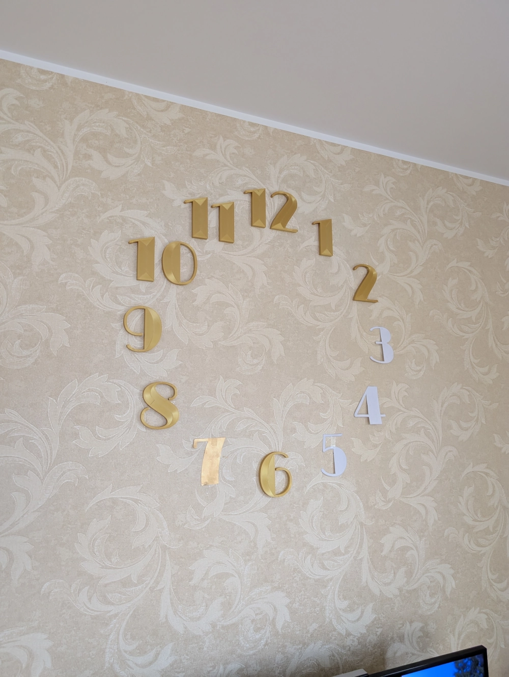 Siena su ant jos pritvirtintais 3D spausdintais ir iškirptais popieriniais skaičiais.