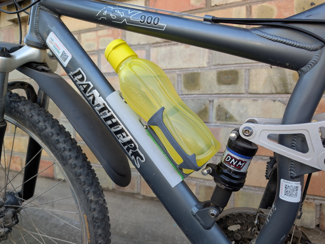 Dviratis su prie rėmo pritvirtintu 3D spausdintu Tupperware gertuvės laikikliu.