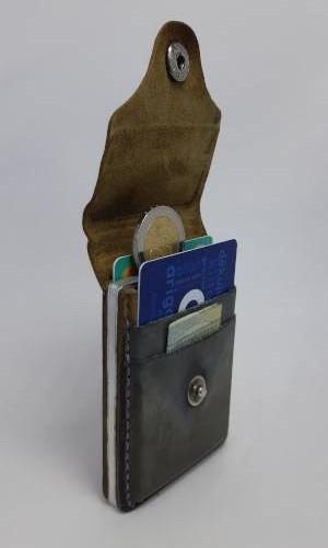 Atidaryta piniginė su aliumininiu rėmeliu monetoms ir vietomis kortelėms.